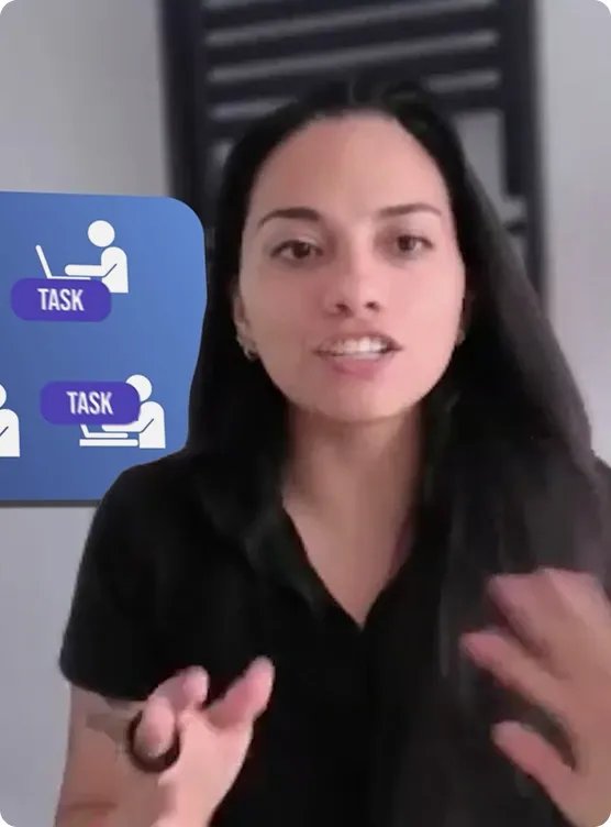 Woman with long dark hair speaking and gesturing with her hands in front of a screen displaying icons of people working on laptops with the word 'TASK'.